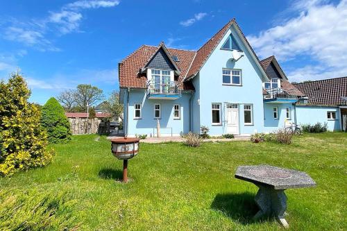 une maison bleue avec un mangeoire d'oiseaux dans la cour dans l'établissement Sunshine, à Prerow