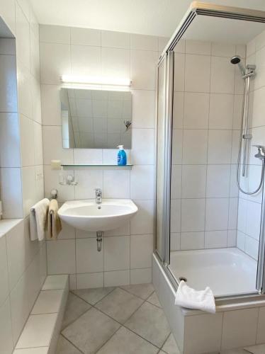 a white bathroom with a sink and a shower at Haus-Kleist-Zimmer-5 in Prerow
