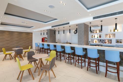 a restaurant with a bar with chairs and tables at Belair Beach Hotel in Ixia