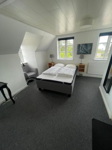 a bedroom with a bed and a chair in it at Øster Hurup Camping in Hadsund