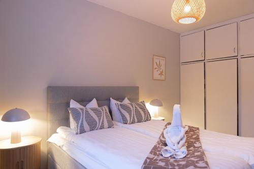 a bedroom with a large white bed with pillows at Santa's City Suite by Book Lapland in Rovaniemi