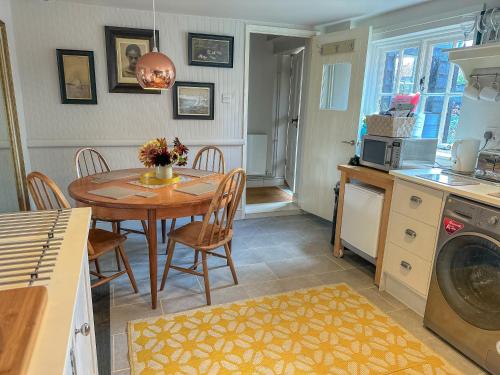 a kitchen and dining room with a table and chairs at Stylish Hayloft sleeping 4 on Norfolk Broads in Dilham
