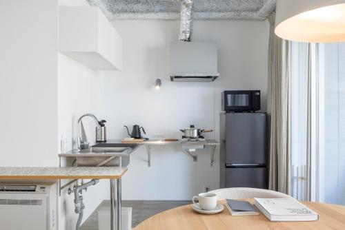 a kitchen with a sink and a refrigerator at まえばしガレリアArt residence & Hotel in Maebashi