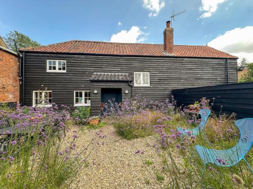 a house with a garden in front of it at Stylish Hayloft sleeping 4 on Norfolk Broads in Dilham