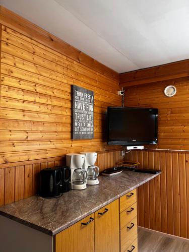 a kitchen with a counter with a tv on a wall at Motelli Rovaniemi in Rovaniemi