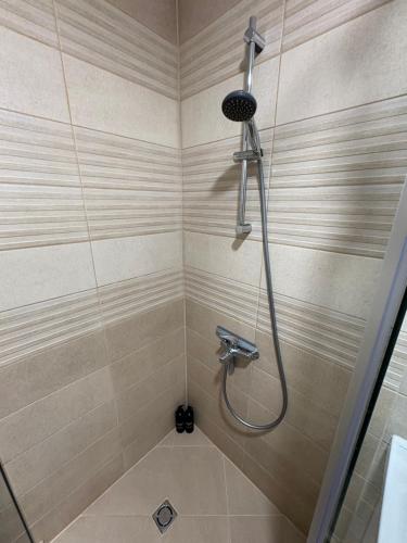 a shower with a hose in a bathroom at Nikea apart 2 in Velingrad