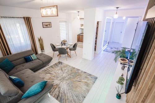 a living room with a couch and a table at Luxury Designer Apartment - Romanescu Park in Craiova