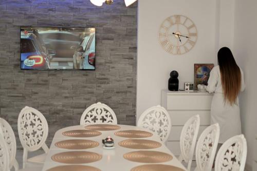 a woman standing in a dining room with a table and chairs at Flori House in Deva