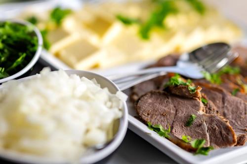 a plate of food with meat and mashed potatoes at Sebnitzer Hof by STEIGER Hotels in Bad Schandau