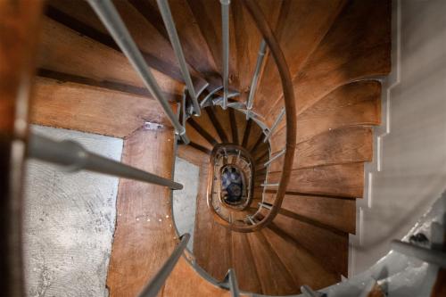 a wooden spiral staircase with a person in the center at Hôtel Henriette in Paris