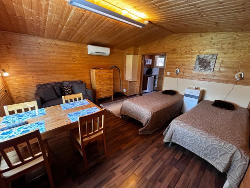 a room with two beds and a table in a room at Motelli Rovaniemi in Rovaniemi