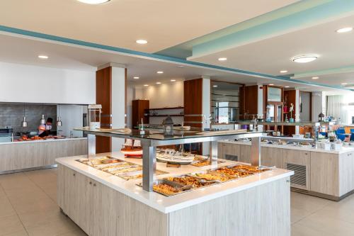 a kitchen with a buffet of food on display at Belair Beach Hotel in Ixia