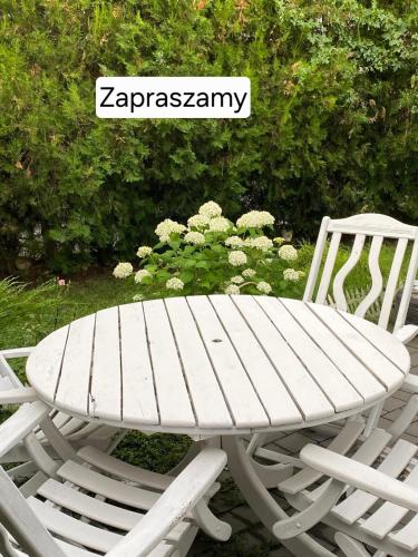 a white picnic table next to a white chair at Dom Zaufanie in Uniejow