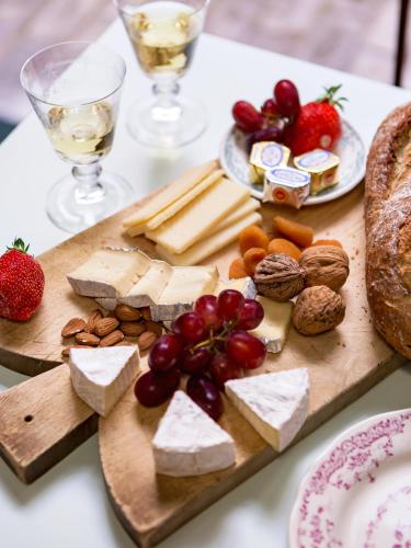 a cutting board with cheese and other foods on a table at Hôtel Henriette in Paris