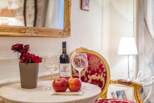 a bottle of wine and two glasses on a table with apples at Villa Segalla in Rovinj