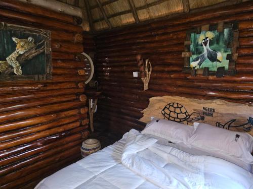 a bedroom with a bed in a log cabin at Nguru Farm Cottages in Wakiso