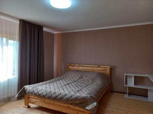 a bedroom with a bed in a room with a window at Садиба Стожари in Vorokhta