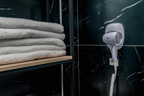 a blow dryer on a wall next to towels at Paloka Collection Hotel in Shëngjin