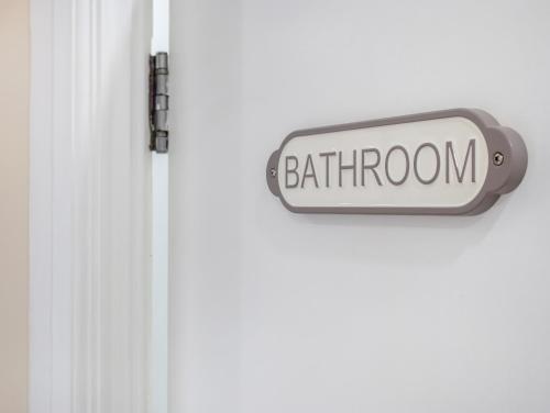 a white door with a bathroom sign on it at Lavish 1 Bedroom Apartment in London