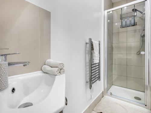 a white bathroom with a tub and a shower at Lavish 1 Bedroom Apartment in London