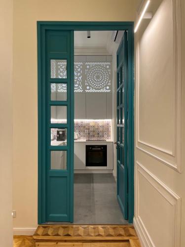 a green door in a room with a kitchen at Paskunji Residence in Tbilisi City