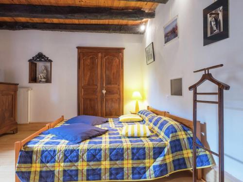 a bedroom with a bed with a blue and yellow blanket at Peaceful Villa in Saint-Jory in Nanthiat