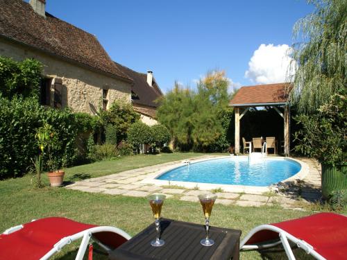 a pool with two glasses of wine on a table at Peaceful Villa in Saint-Jory in Nanthiat