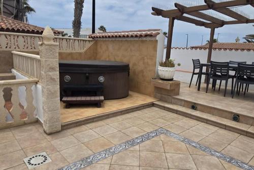 une terrasse avec un bain à remous, une table et des chaises dans l'établissement 3 Bed Villa - Sleeps 6 - Private Pool - Hot Tub- Parking - Wifi, à San Miguel de Abona