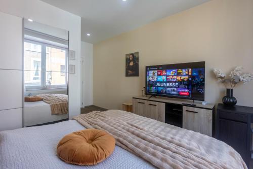 a bedroom with a bed and a flat screen tv at Chambres de luxe SDB WC Privés in Liège