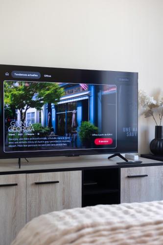 a flat screen tv sitting on top of a cabinet at Chambres de luxe SDB WC Privés in Liège