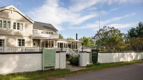 a white house with a sign in front of it at Naya Retreat & Hotell in Mörbylånga