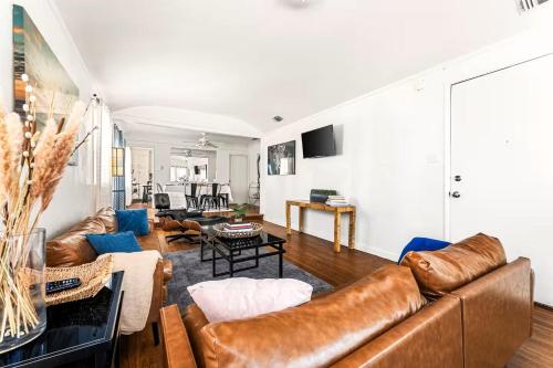 a living room with a brown leather couch at Spacious 4 bedroom home by Melrose and 10 minutes to Hollywood Walk of Fame in Los Angeles
