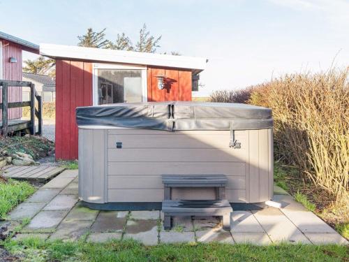 a small garage with a bench in front of a house at 6 person holiday home in Lemvig in Lemvig