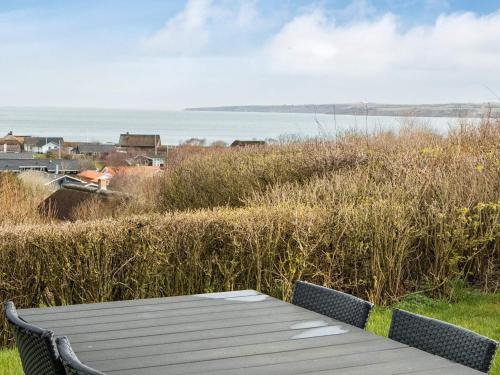 a wooden bench sitting on top of a grassy field at 6 person holiday home in Lemvig in Lemvig