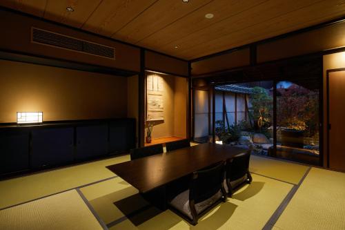 a dining room with a wooden table and chairs at Enso Machiya in Kyoto