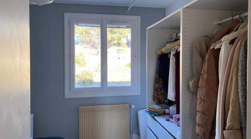 马赛Chambre dans maison partagée的一间带窗户和步入式衣柜的蓝色房间