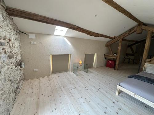 a bedroom with a bed and a stone wall at La finestra sul grappa in Seren del Grappa
