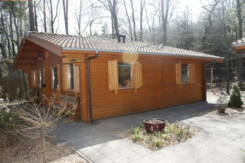a small wooden cabin in the woods at Lodges Veluwse Poort in Dieren