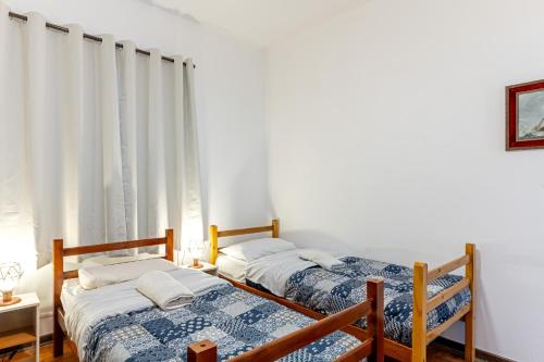 two beds in a room with white walls at Casas no Tatuapé Garagem e Portão Automático 284 a 314 in Sao Paulo