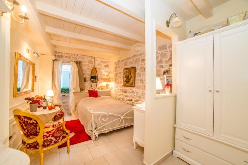 ein Schlafzimmer mit einem Bett, einem Tisch und einem Stuhl in der Unterkunft Villa Segalla in Rovinj