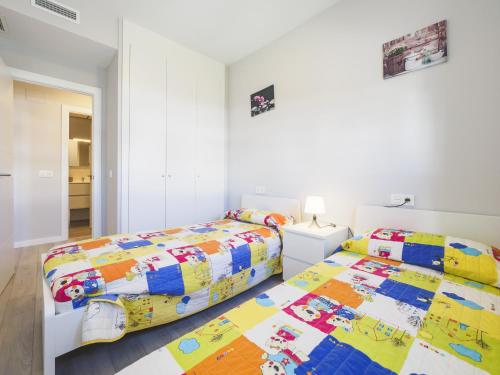 two beds in a room with white walls at Cubo's Marques Apartment with Free Parking in Almayate Alto