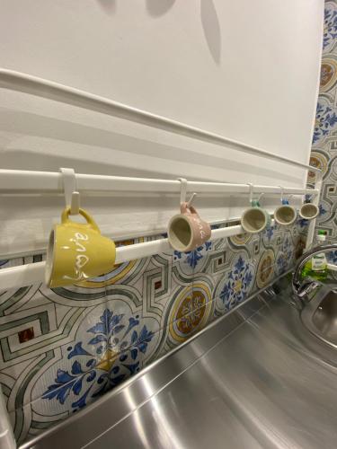 a kitchen sink with some cups on a wall at Ventidue Venti in Bari