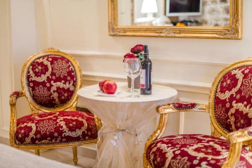 a table with a glass of wine and two chairs at Villa Segalla in Rovinj