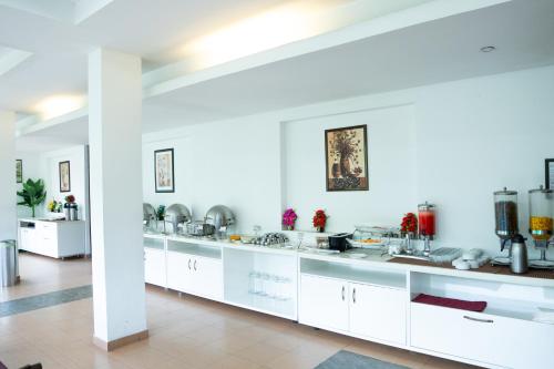 a large kitchen with white cabinets and sinks at Hotel C7 Munnar in Munnar