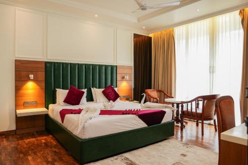 a bedroom with a large bed with a green headboard at Hotel C7 Munnar in Munnar