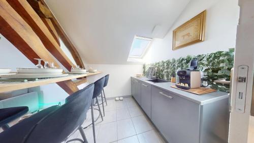 a kitchen with a counter and chairs in a room at Appartement de Charme in Lacroix-Saint-Ouen