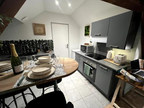 a kitchen with a dining table and a kitchen with a stove at Appartement de Charme in Lacroix-Saint-Ouen
