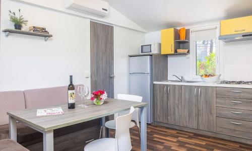 a small kitchen with a table and a counter top at Aminess Planet Camping Holiday Homes Port9 in Korčula