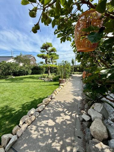 a garden with a stone path and a basket at 鴨川シーサイドヴィラ in Kamogawa