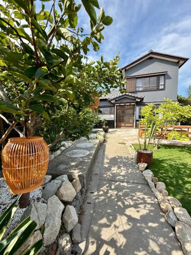 a house with a stone walkway in front of a house at 鴨川シーサイドヴィラ in Kamogawa